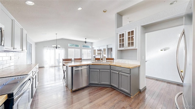15926 Butterwort Cir, Parker, CO 80134 - kitchen featuring appliances with stainless steel finishes, butcher block counters, gray cabinets, lofted ceiling, and light wood-type flooring