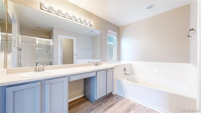 15926 Butterwort Cir, Parker, CO 80134 - bathroom with double vanity, a bath, a stall shower, and wood finished floors