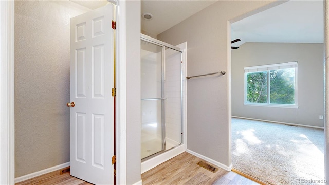 15926 Butterwort Cir, Parker, CO 80134 - bathroom featuring a stall shower, wood finished floors, and lofted ceiling