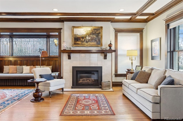 living room with crown molding, a fireplace, and hardwood / wood-style flooring