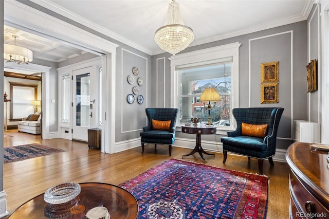 sitting room featuring beamed ceiling, an inviting chandelier, wood-type flooring, ornamental molding, and coffered ceiling