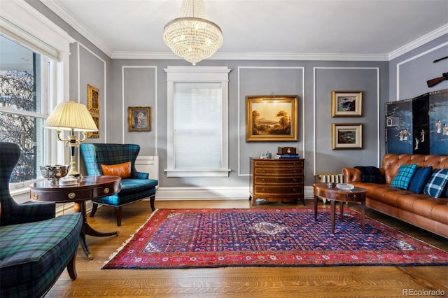 living area featuring an inviting chandelier, crown molding, and hardwood / wood-style floors