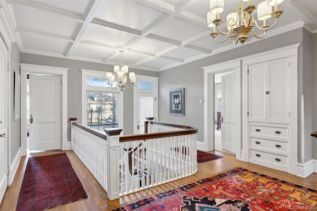 hall with beam ceiling, a notable chandelier, and coffered ceiling