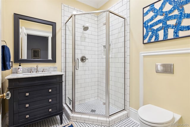 bathroom featuring toilet, tile patterned floors, a shower with door, vanity, and crown molding