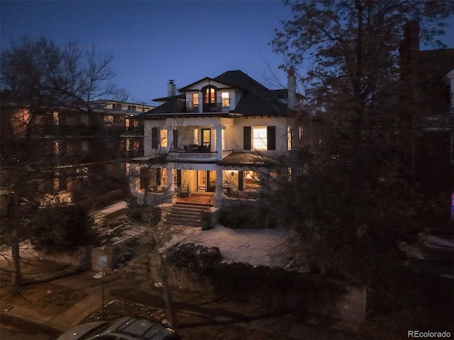 back house at twilight with a balcony