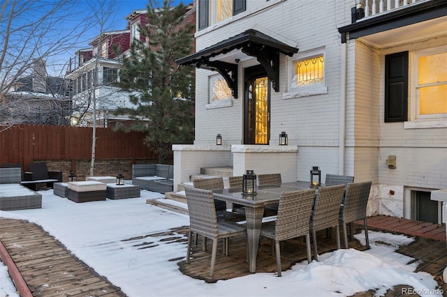 snow covered deck featuring an outdoor living space with a fire pit