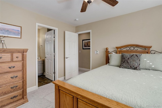 bedroom featuring baseboards, connected bathroom, ceiling fan, and light carpet