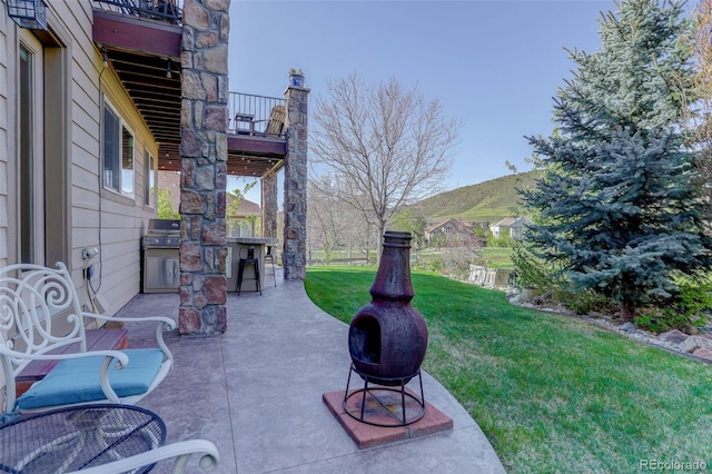 view of yard featuring a patio, a balcony, and area for grilling