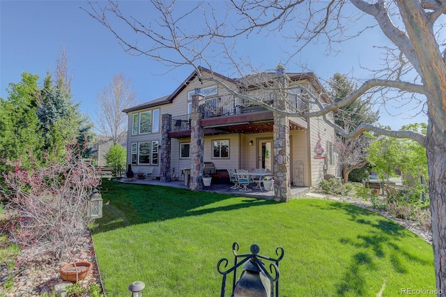 rear view of house with a patio, a lawn, and a balcony