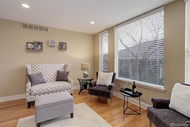 living area with visible vents, baseboards, and light wood-style floors