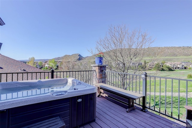 deck with a hot tub and a mountain view