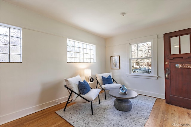 living area featuring plenty of natural light, wood finished floors, and baseboards