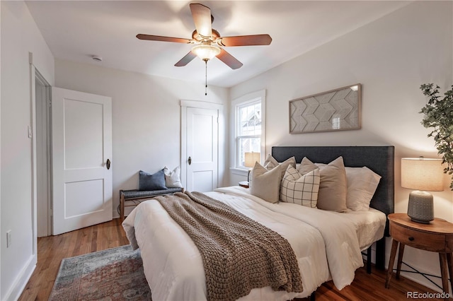 bedroom with wood finished floors, a ceiling fan, and baseboards