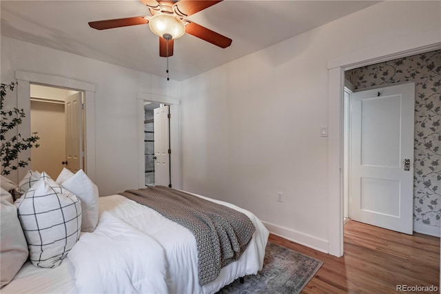 bedroom with wood finished floors, baseboards, and a ceiling fan