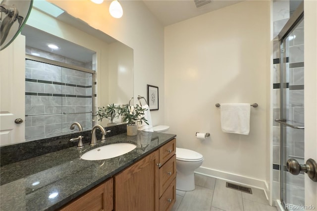 bathroom featuring baseboards, a shower stall, vanity, toilet, and tile patterned flooring
