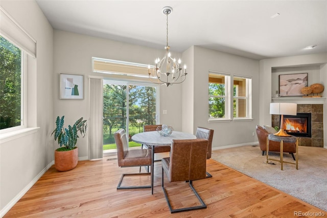 15414 Xenia Ct, Thornton, CO 80602 - dining space with a chandelier, wood finished floors, and a tile fireplace