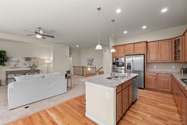 15414 Xenia Ct, Thornton, CO 80602 - kitchen featuring stainless steel appliances, open floor plan, light wood-style flooring, light stone countertops, and recessed lighting