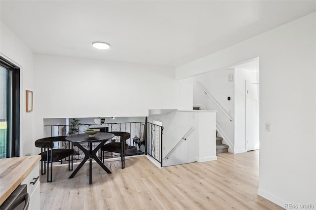 dining room with light wood-style flooring and baseboards