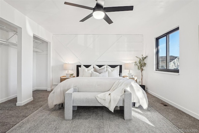carpeted bedroom featuring baseboards, ceiling fan, and multiple closets