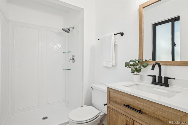 bathroom with a shower stall, toilet, and vanity