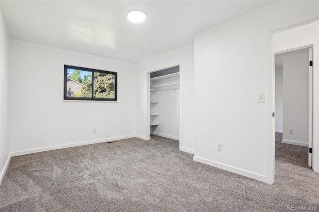 unfurnished bedroom with carpet flooring, baseboards, and a closet