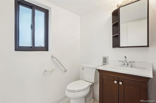 half bathroom with baseboards, toilet, and vanity