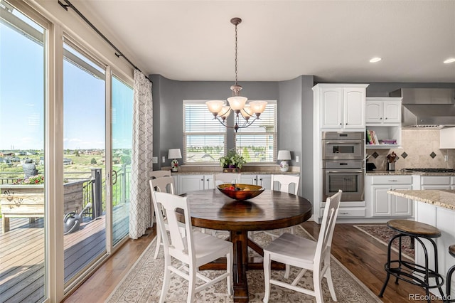 dining room with a chandelier, light wood finished floors, and recessed lighting