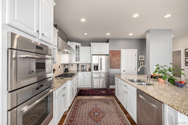 kitchen with appliances with stainless steel finishes, a sink, white cabinets, and recessed lighting