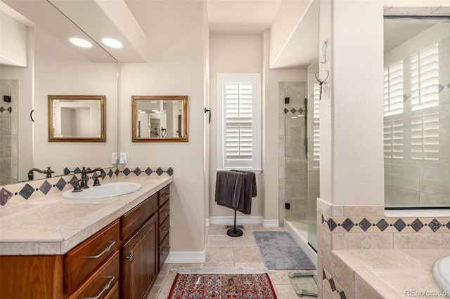bathroom with a shower stall, vanity, tile patterned floors, and baseboards