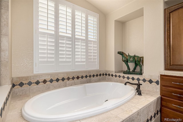 bathroom featuring a garden tub and lofted ceiling