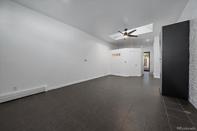 tiled empty room with ceiling fan and a skylight