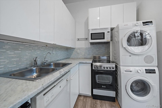 interior space featuring stacked washer / dryer, sink, and dark wood-type flooring