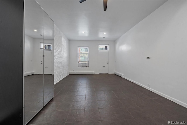 foyer entrance with ceiling fan and brick wall