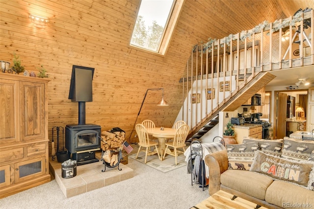 244 Lariat Loop, Hartsel, CO 80449 - living room with a high ceiling, carpet flooring, a wood stove, stairs, and wood walls
