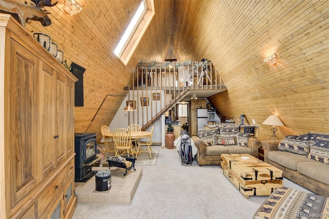 244 Lariat Loop, Hartsel, CO 80449 - carpeted living area featuring a wood stove, vaulted ceiling, wooden walls, stairs, and wooden ceiling