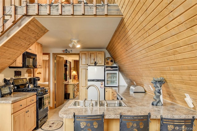 244 Lariat Loop, Hartsel, CO 80449 - kitchen featuring black appliances, light brown cabinets, light countertops, and wood walls
