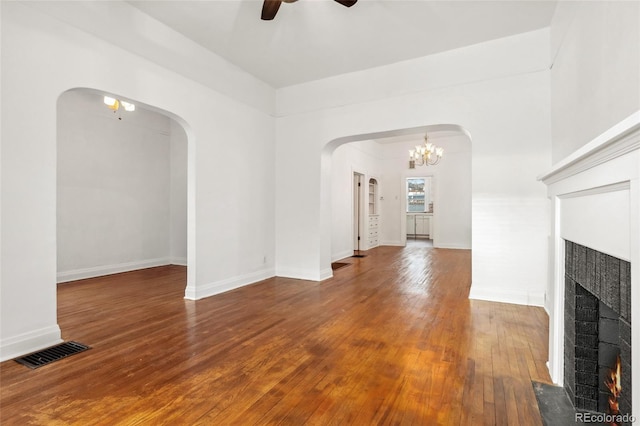 1748 S Logan St, Denver, CO 80210 - unfurnished living room with a warm lit fireplace, a ceiling fan, arched walkways, wood-type flooring, and a chandelier