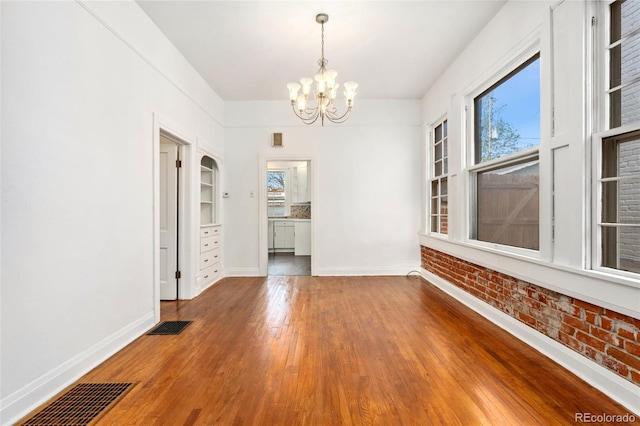 1748 S Logan St, Denver, CO 80210 - unfurnished dining area with a chandelier, plenty of natural light, wood finished floors, and baseboards