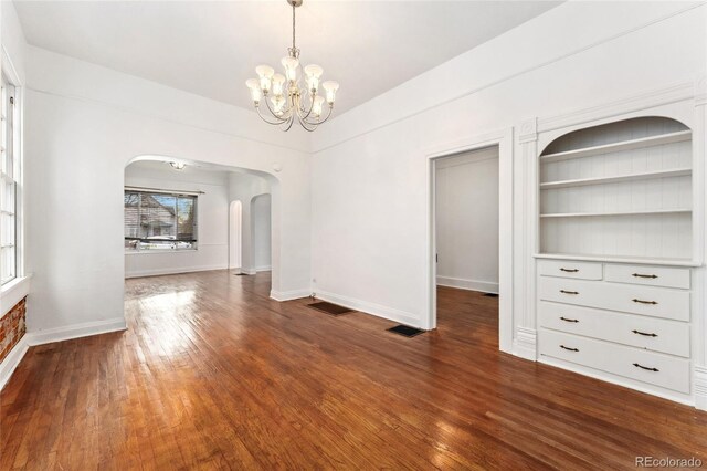 1748 S Logan St, Denver, CO 80210 - unfurnished dining area featuring arched walkways, a chandelier, wood finished floors, and baseboards