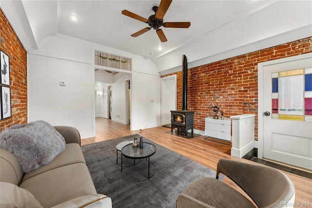 1748 S Logan St, Denver, CO 80210 - living room featuring brick wall, a ceiling fan, a wood stove, lofted ceiling, and wood finished floors