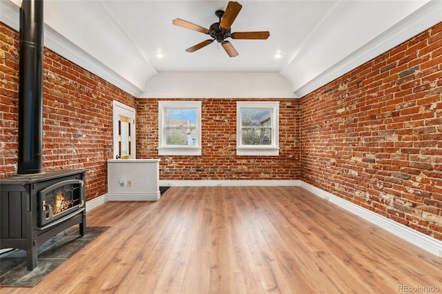 1748 S Logan St, Denver, CO 80210 - unfurnished living room featuring a wood stove, baseboards, light wood-type flooring, vaulted ceiling, and a ceiling fan