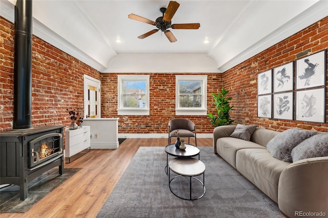 1748 S Logan St, Denver, CO 80210 - living room with brick wall, a wood stove, wood finished floors, vaulted ceiling, and a ceiling fan