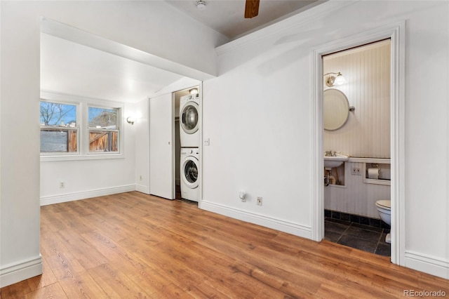1748 S Logan St, Denver, CO 80210 - laundry area with stacked washing machine and dryer, wood finished floors, and baseboards