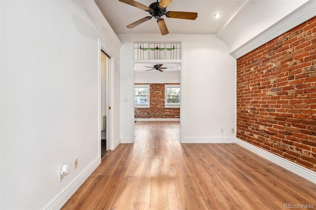 1748 S Logan St, Denver, CO 80210 - empty room with brick wall, a ceiling fan, light wood-style flooring, and baseboards