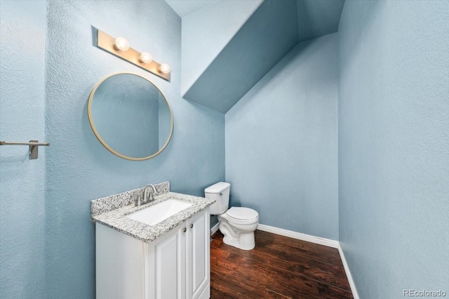 bathroom with vanity, toilet, and hardwood / wood-style floors