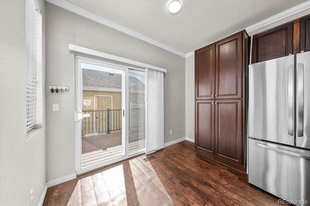 kitchen featuring crown molding, dark brown cabinets, dark hardwood / wood-style floors, and stainless steel refrigerator