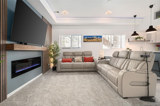 25362 E Indore Dr, Aurora, CO 80016 - carpeted living room featuring a tray ceiling, a glass covered fireplace, ornamental molding, and baseboards
