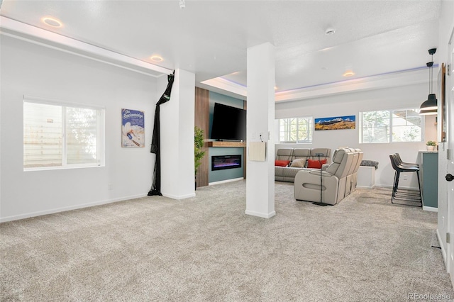 25362 E Indore Dr, Aurora, CO 80016 - carpeted living area with a glass covered fireplace, baseboards, and a tray ceiling