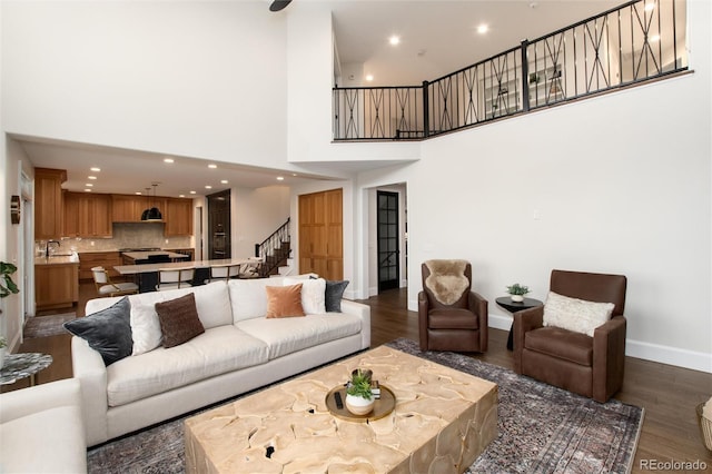 living room featuring dark wood-type flooring and a towering ceiling