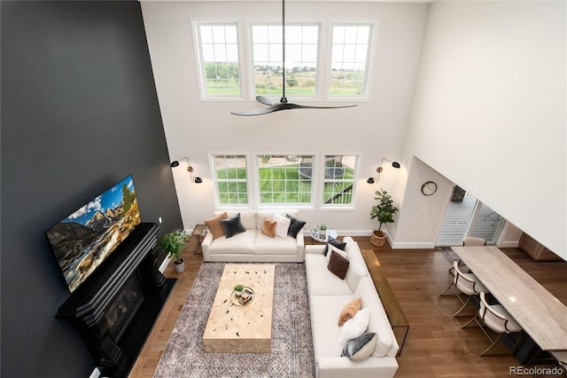 living room with hardwood / wood-style floors, plenty of natural light, and a high ceiling